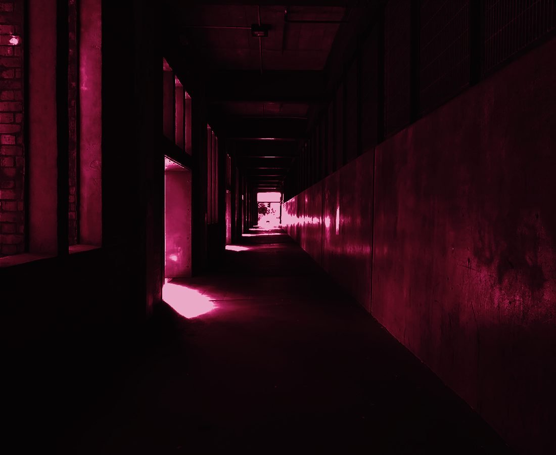 A long institutional corridor with light at the far end